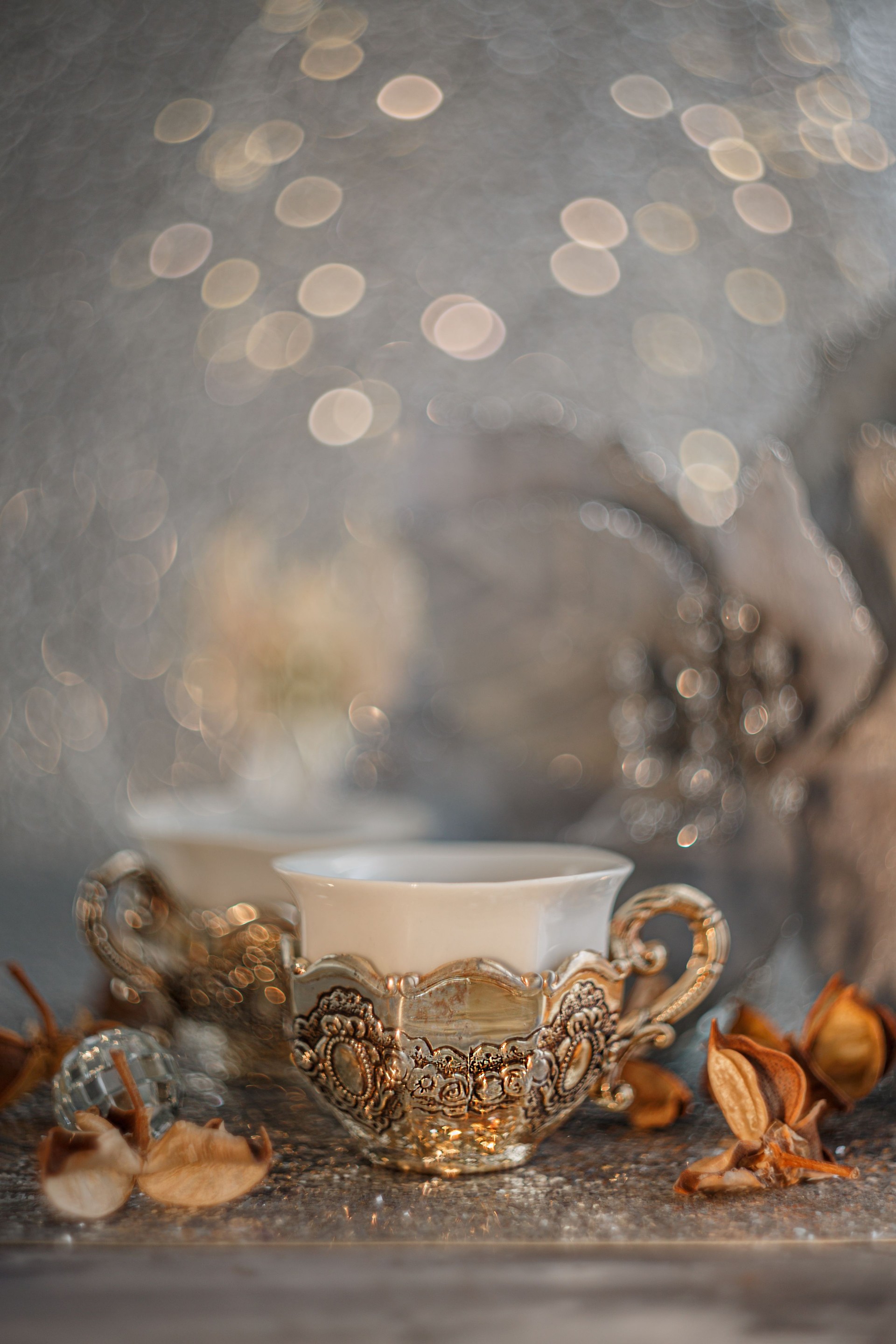 Vintage coffee silver cup and blurred light background with white bokeh. Soft focus. Antique white porcelain. Poinsettia flower Vintage coffee silver cup and blurred light background with white bokeh. Soft focus. Antique white porcelain. Poinsettia flower